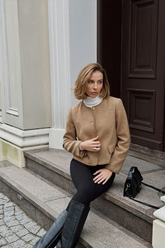 a lady wears a beige wool jacket with black skinny jeans